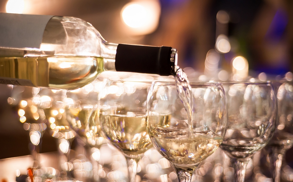 wine waiter pours white wine into wine glasses closeup glassxa
